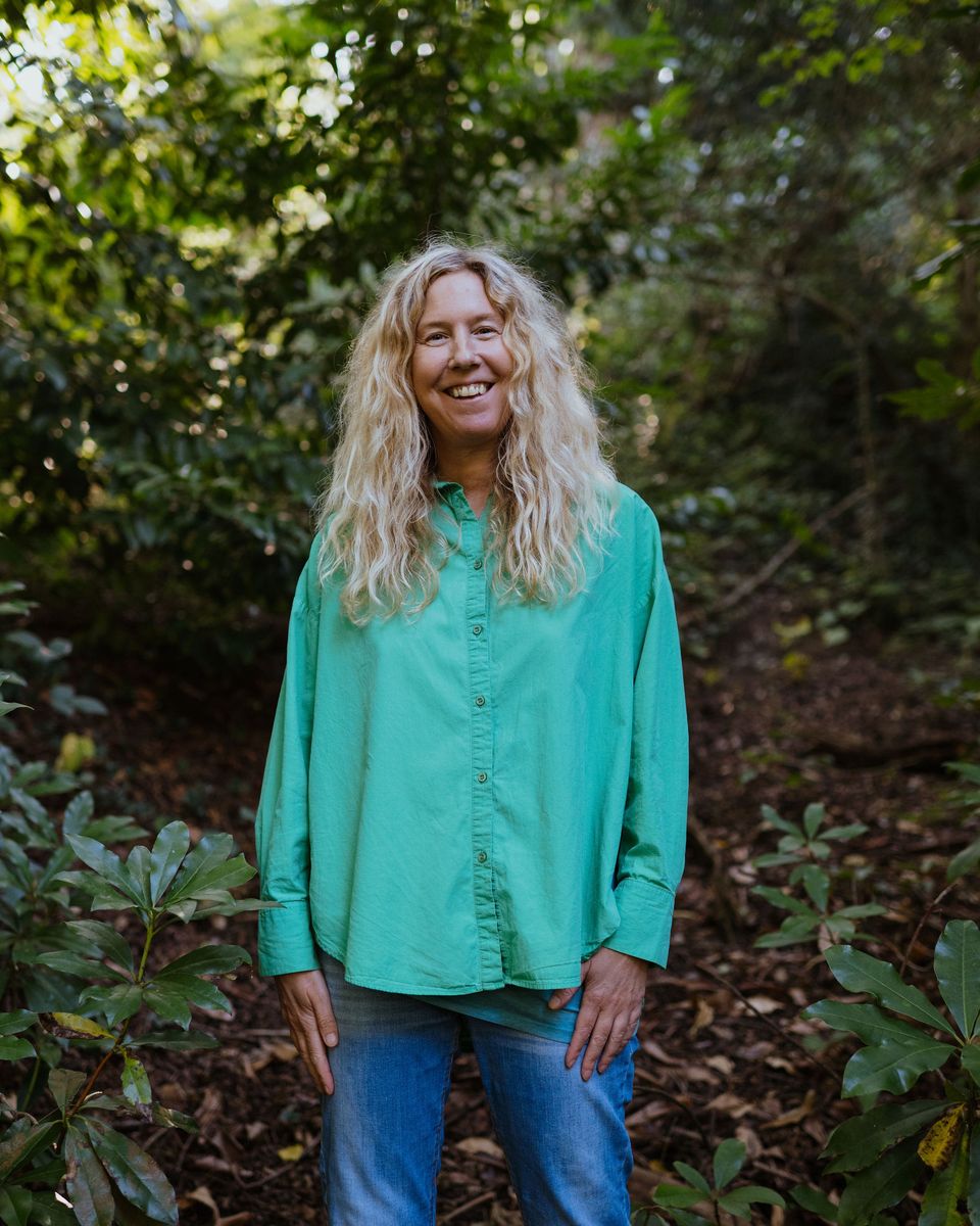 Anne-Marie smiling warmly in the woods